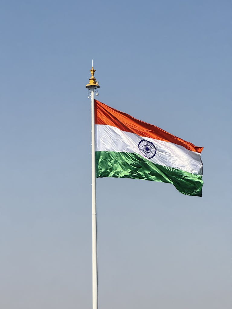 The national flag of India waving under a clear blue sky, symbolizing national pride.